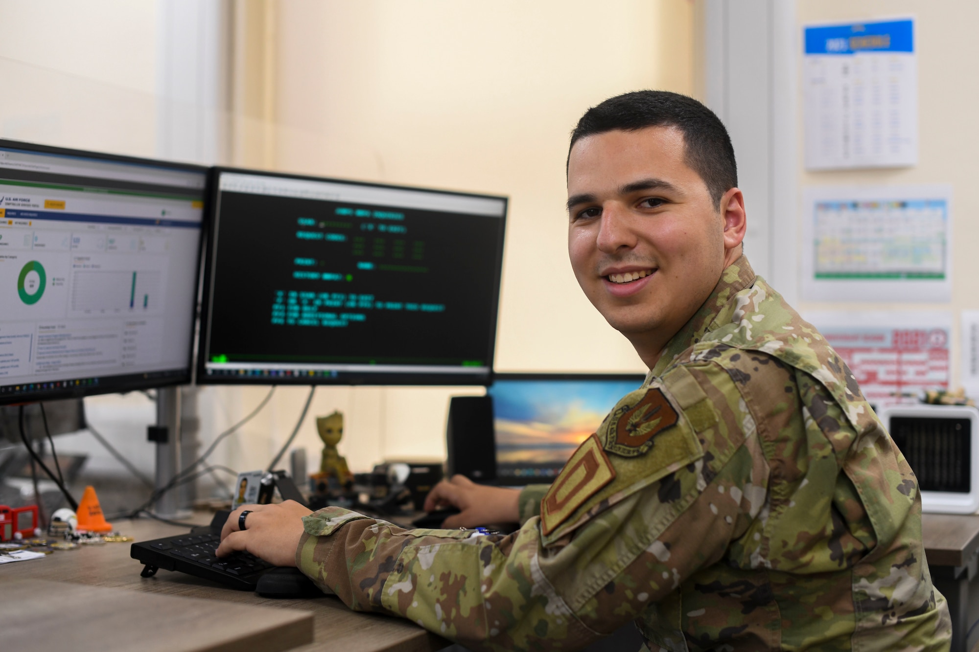 U.S. Air Force Senior Airman Jake Pineiros, 100th Comptroller Squadron finance technician poses in front of his desk on Aug. 3, 2021 at Royal Air Force Mildenhall, England. Pineiros pursues his Community College of the Air Force degree and is two classes away from completion. (U.S. Air Force Photo by Senior Airman Antonia Herrera)