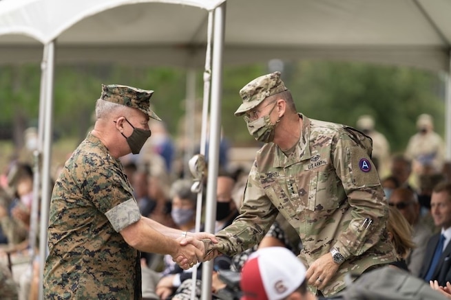 U.S. Army Central outgoing Commanding General, Lt. Gen. Terry Ferrell, shakes the U.S. Central Command's Commander, Marine Corps Gen. Kenneth McKenzie's hand after his remarks during USARCENT's Change of Command ceremony at Patton Hall's Lucky Park on Shaw Air Force Base, S.C., Aug. 4, 2021. Mckenzie officiated the ceremony for CENTCOM's Army Service Component Command. (U.S. Army photo by Sgt. Leo Jenkins)