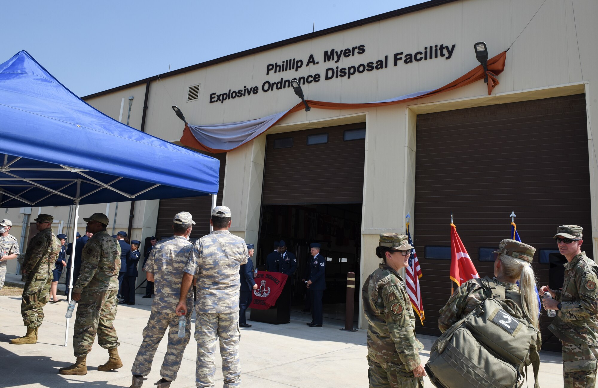 Airmen stand near EOD facility.