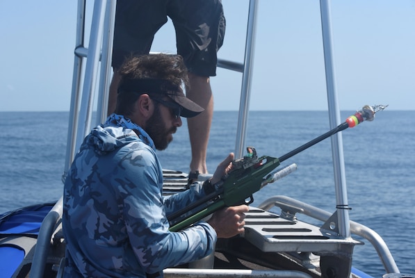 Daniel Webster prepares to tag a Cuvier’s beaked whale as part of a Behavioral Response Experiment funded by the U.S. Navy.