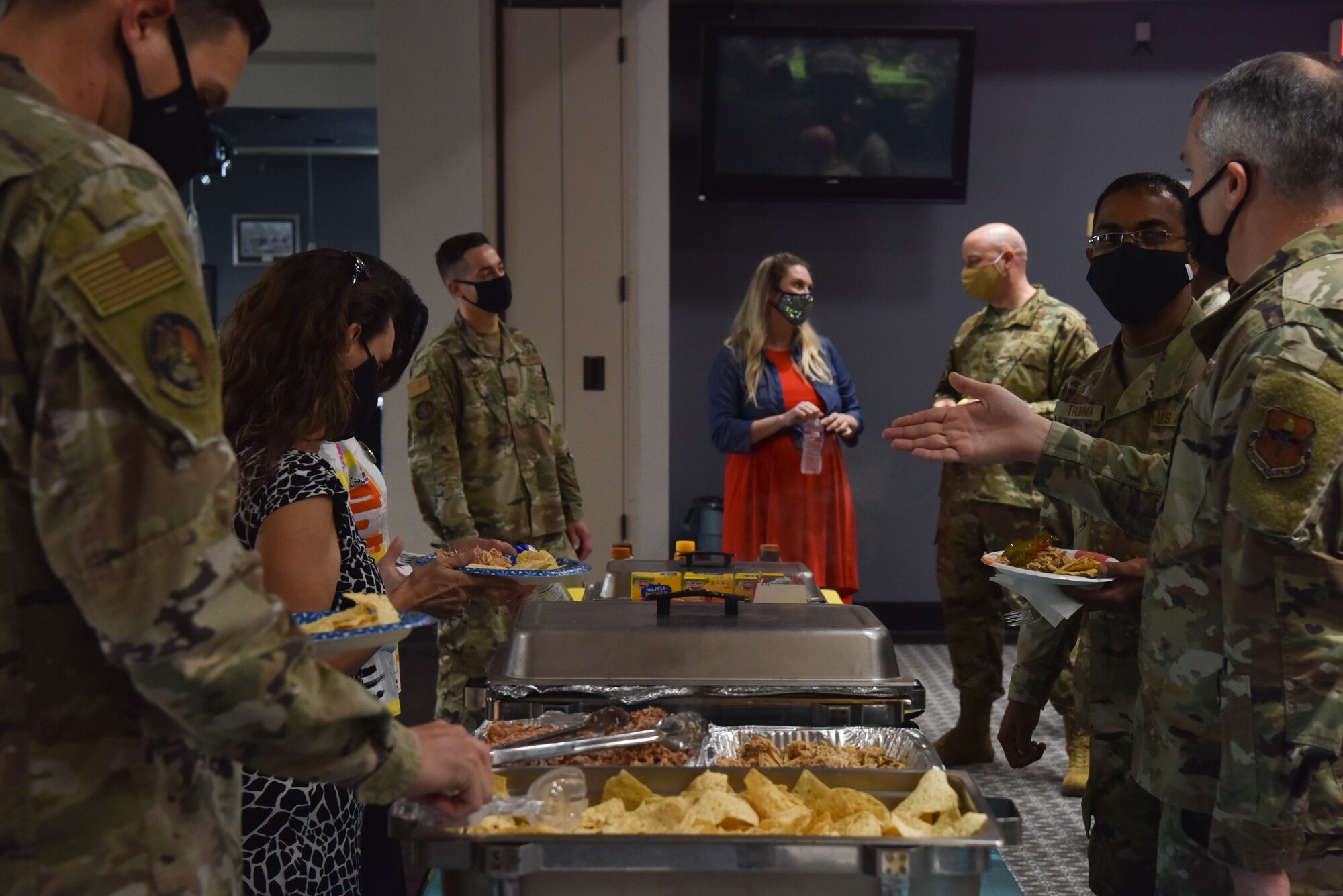U.S. Air Force Col. Matthew Reilman, 17th Training Wing commander, speaks to April Miller, 17th Medical Group health care promotions coordinator at the Care for the Caregiver event, while members stand in line for food on Goodfellow Air Force Base, Texas, Aug. 5, 2021. During the occasion members were treated to a nacho bar, ice cream, and various refreshments. (U.S. Air Force photo by Senior Airman Jermaine Ayers)