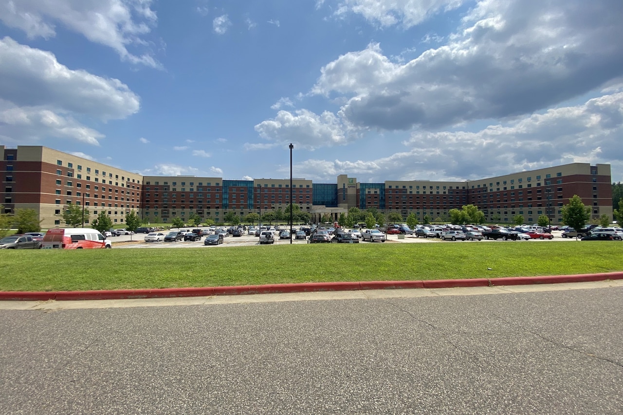 Vehicles are parked in front of a large building.