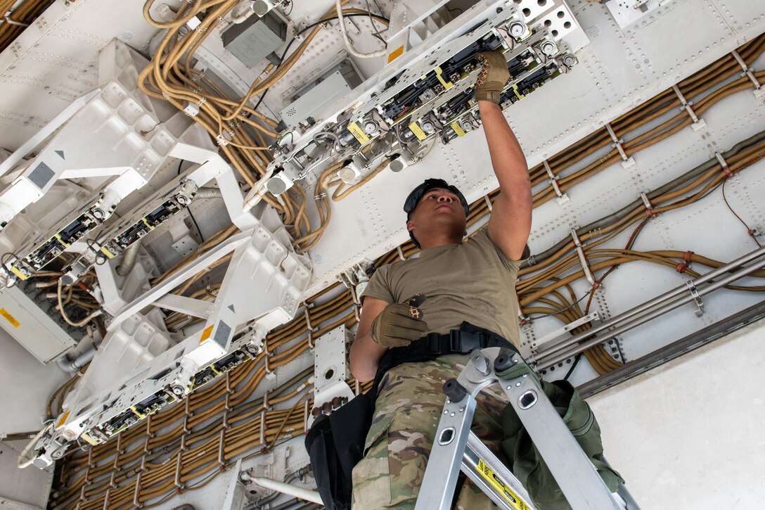 Military member inspects bomb rack