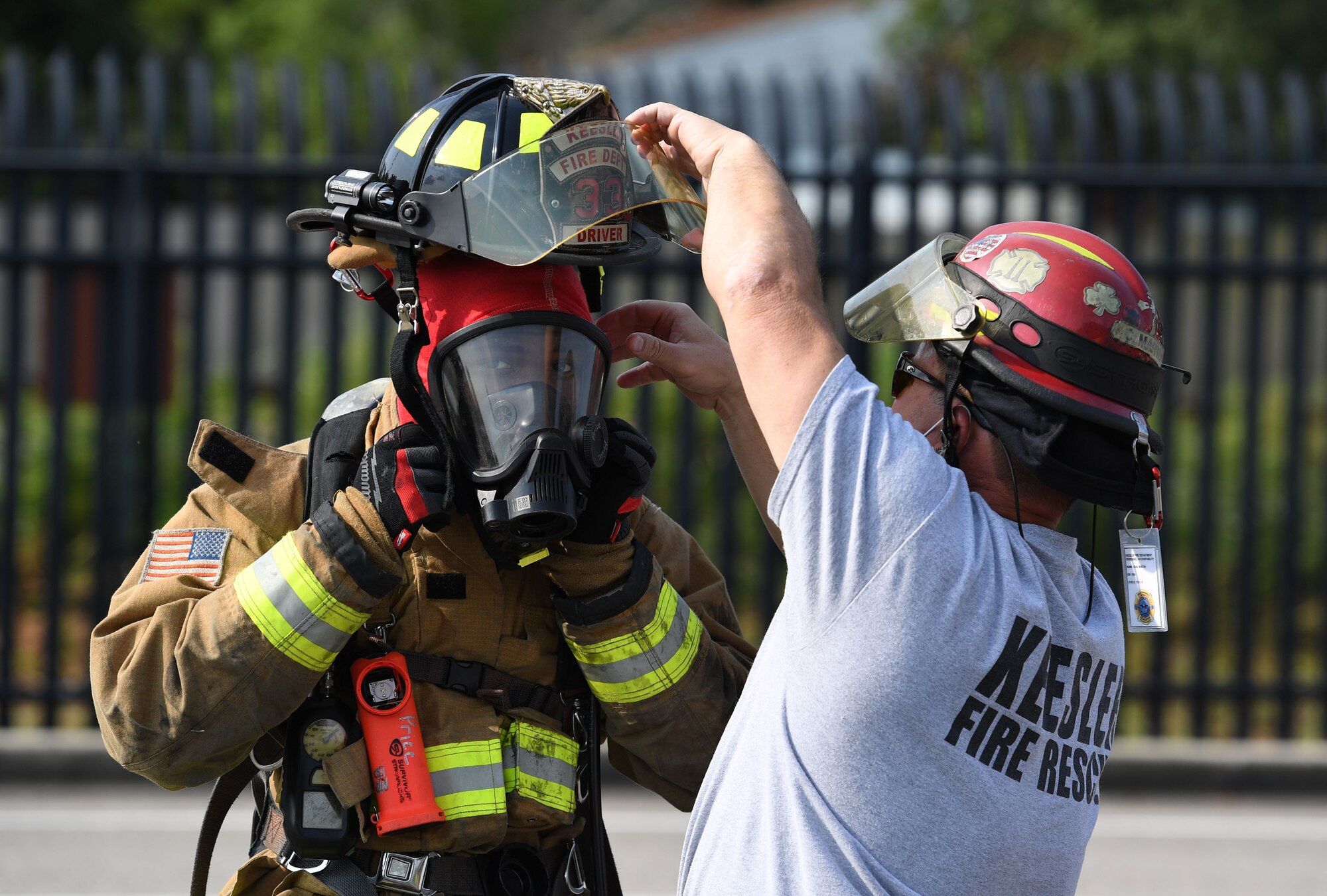 Chad Martin, 81st Civil Engineering Installation Squadron firefighter, assists U.S. Air Force Airman 1st Class Antonio Price, 81st CES firefighter, with his helmet during a Chemical, Biological, Radiological, Nuclear exercise at Keesler Air Force Base, Mississippi, Aug. 6, 2021. The Ready Eagle exercise tested the base's ability to respond to and recover from a mass casualty event. (U.S. Air Force photo by Kemberly Groue)