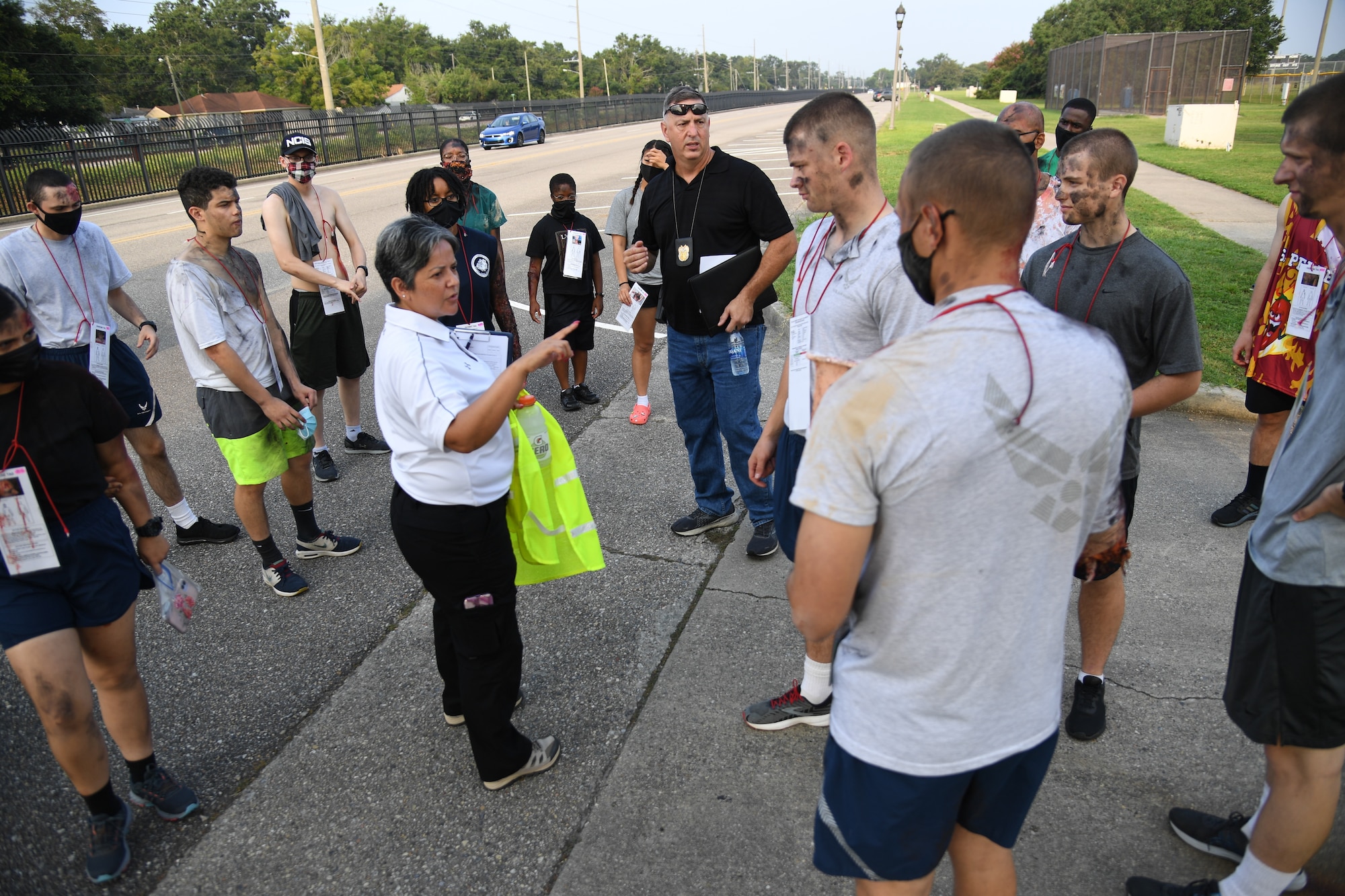 Norma Grandberry, Booz Allen Hamilton medical readiness exercise facilitator, provides instruction to Airmen portraying victims during a Chemical, Biological, Radiological, Nuclear exercise at Keesler Air Force Base, Mississippi, Aug. 6, 2021. The Ready Eagle exercise tested the base's ability to respond to and recover from a mass casualty event. (U.S. Air Force photo by Kemberly Groue)