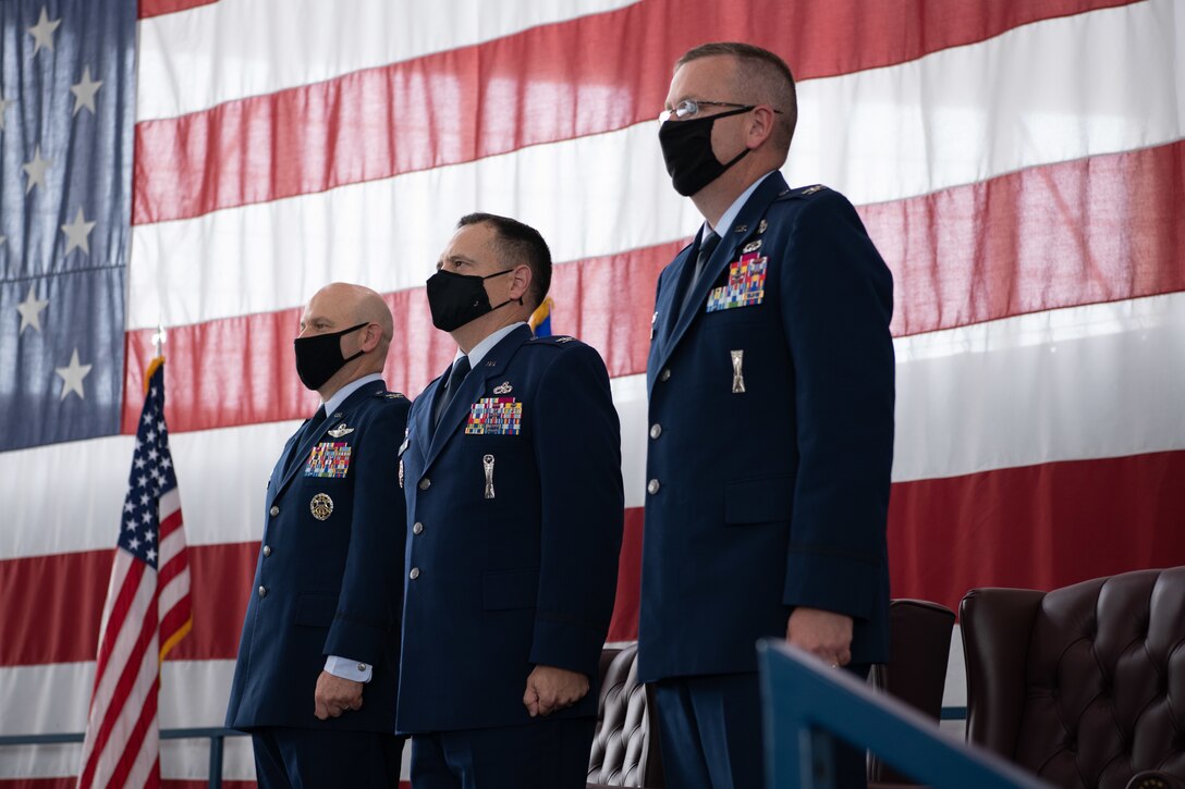 Col. Joseph Sheffield, the 28th Bomb Wing commander, left, Col. Nathan Mitchell, the 28th Maintenance Group incoming commander, middle, and Col. Chad Heyen, the 28th Maintenance Group outgoing commander, right, stand for the playing of the Air Force song during a change of command ceremony on Ellsworth Air Force Base, S.D., August 4, 2021.