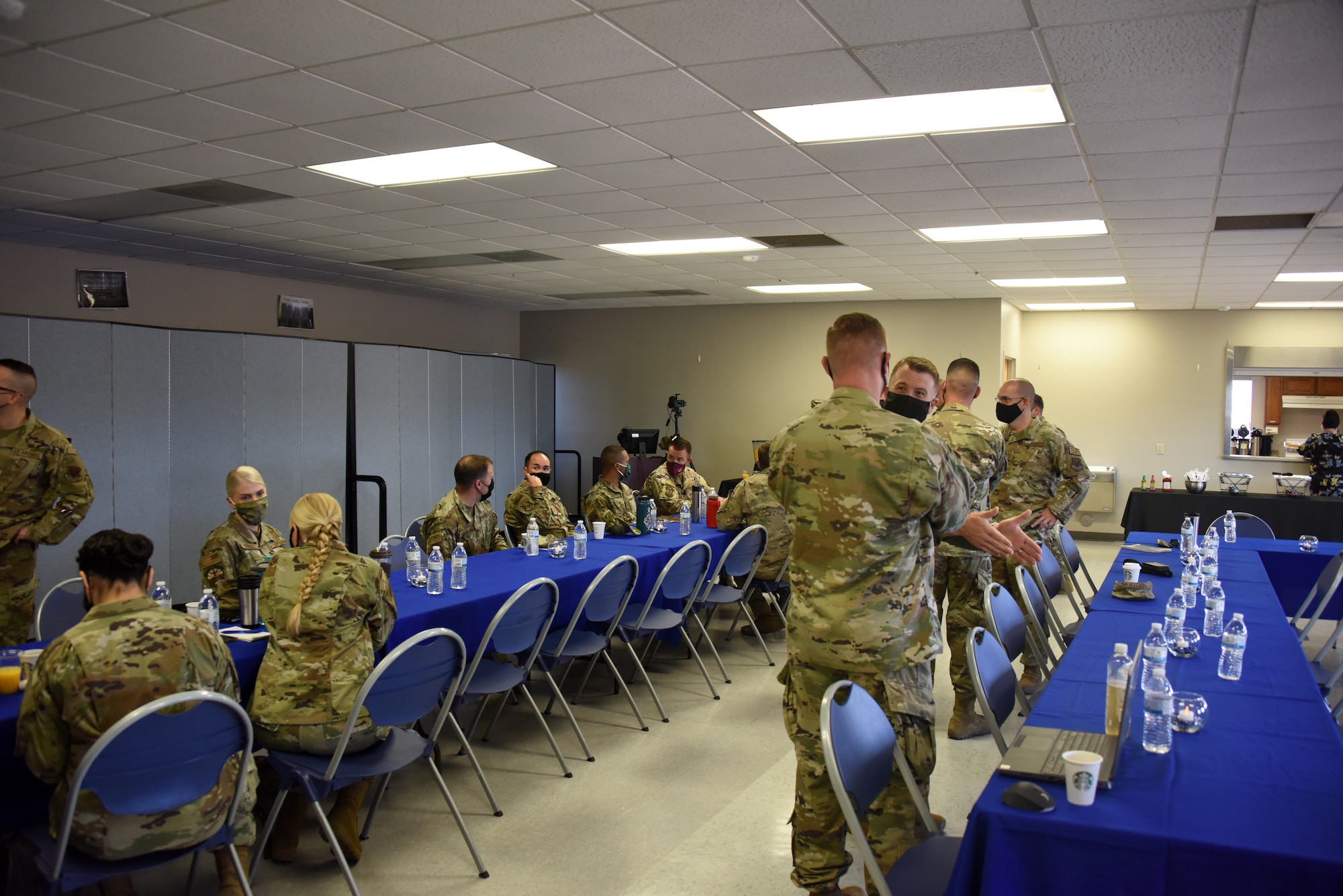 A photo of Airmen standing in a room.