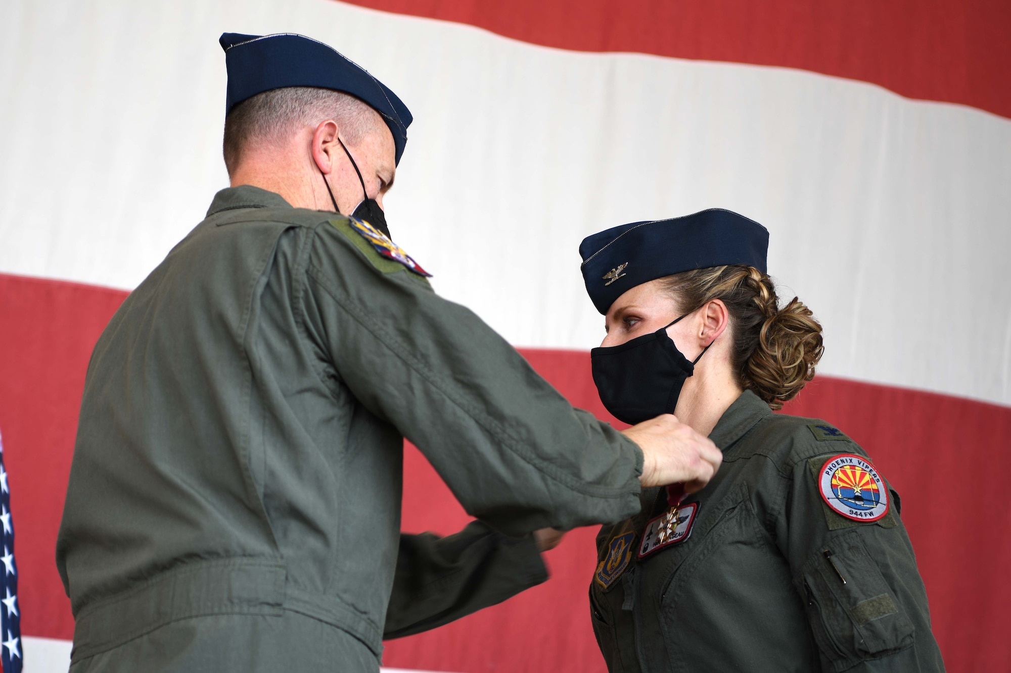 LUKE AIR FORCE BASE, ARIZ. – Reserve Citizen Airman Col. Mark Van Brunt, 944th Fighter Wing commander, presents Reserve Citizen Airman Col. Trena Savageau the Legion of Merit for her performance as the 944th Fighter Group commander at the change of command ceremony, August 6, 2021, at Luke Air Force Base. Savageau was responsible for training F-16 Fighting Falcon and F-35 Lightning II pilots in three squadrons and two geographically separated locations to meet the requirements of combat air forces. (U.S. Air Force Photo/Tech. Sgt. Courtney Richardson)