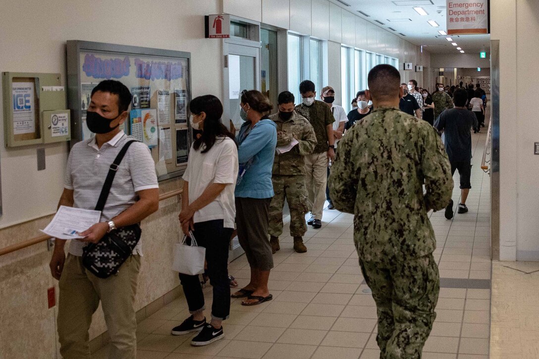 沖縄県北谷町にある米海兵隊基地キャンプ・フォスターの中にある米海軍病院で、新型コロナワクチン接種を受けるために順番を待つ日本人従業員と米軍関係者