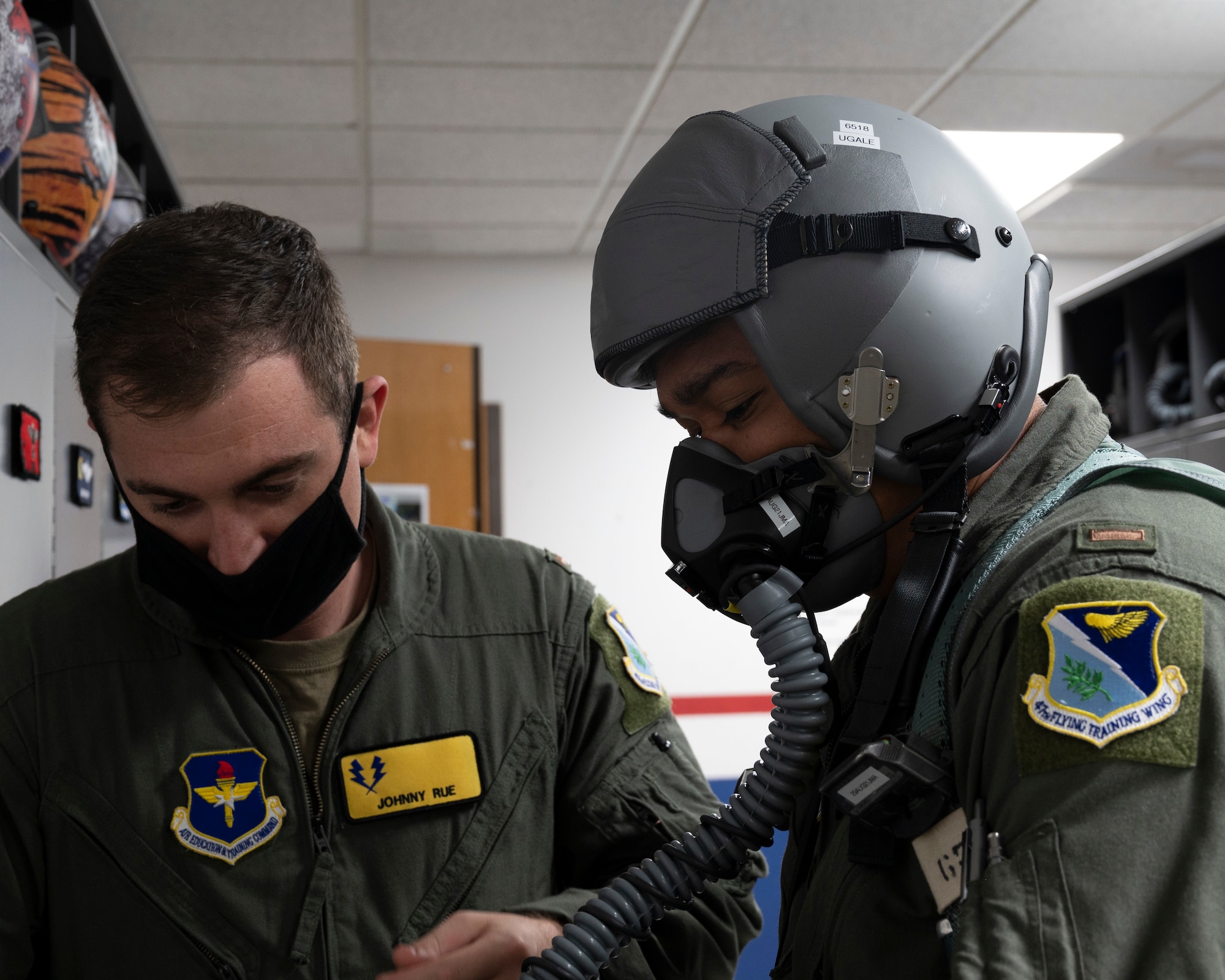 U.S. Air Force 2nd Lt. Johnny Rue, left checks the equipment of fellow student U.S. Air Force 2nd Lt. Christopher Ugale, both with the 47th Student Squadron, before Ugale’s dollar ride flight at Laughlin Air Force Base, Texas on August 4, 2021. Equipment checks are a vital part of preparations for a flight and help ensure a pilot’s safety while flying. (U.S. Air Force Photo by Senior Airman Nicholas Larsen)