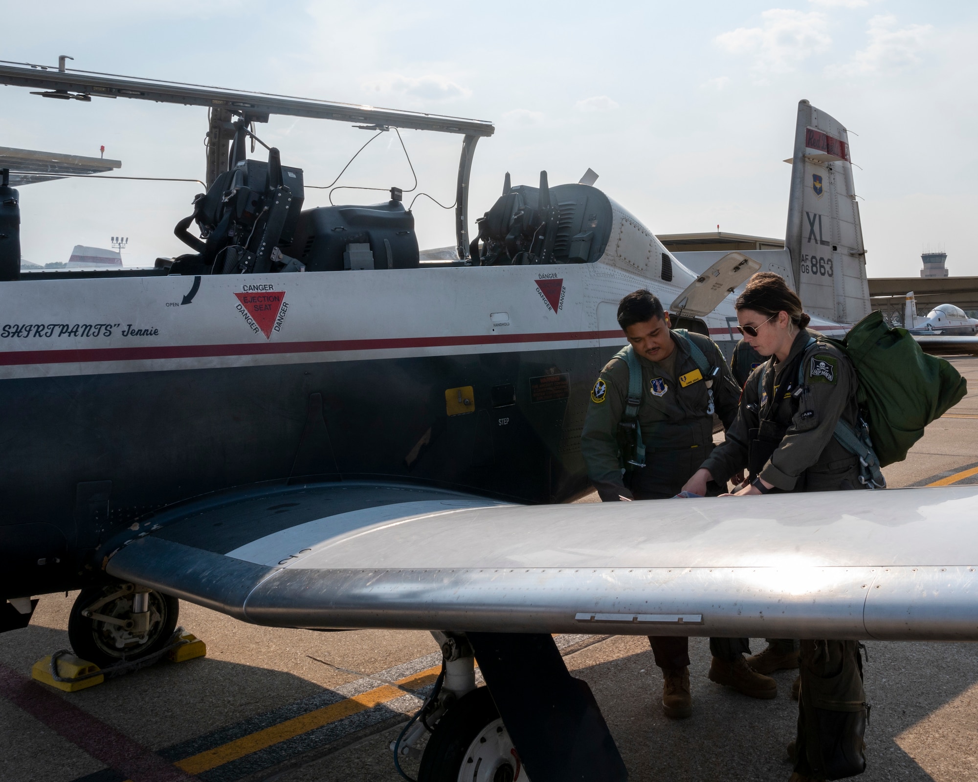U.S. Air Force 2nd Lt. Christopher Ugale, a student pilot with the 47th Student Squadron, looks over his final pre flight checklist with before entering a T-6 Texan II for his Dollar Flight with, U.S. Air Force Capt. Sarah Fotsch at Laughlin Air Force Base, Texas on August 4, 2021.  The Dollar Flight is the first flight in a real aircraft for a student pilot and marks a major milestone in the career of a pilot. (U.S. Air Force Photo by Senior Airman Nicholas Larsen)