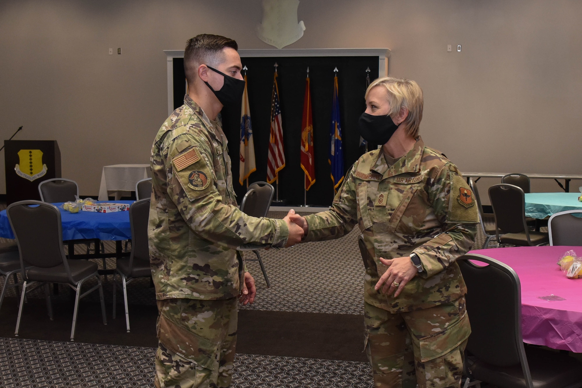 U.S. Air Force Chief Master Sergeant Casy Boomershine, 17th Training Wing command chief, coins Tech. Sgt. Joseph Doyle, 17th TRW non-commissioned officer in charge of religious affairs during the Care for the Caregivers event on Goodfellow Air Force Base, Texas, Aug. 5, 2021. Doyle was coined for his role in facilitating the event. (U.S. Air Force photo by Senior Airman Jermaine Ayers)
