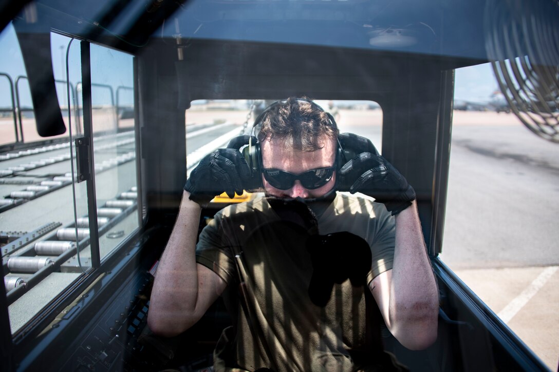 U.S. Air Force Airman 1st Class Andrew Morris, 190th Logistics Readiness Squadron air freight apprentice, puts on hearing protection inside a Tunner 60K Aircraft Cargo Loader/Transporter at Altus Air Force Base, Oklahoma, July 27, 2021.