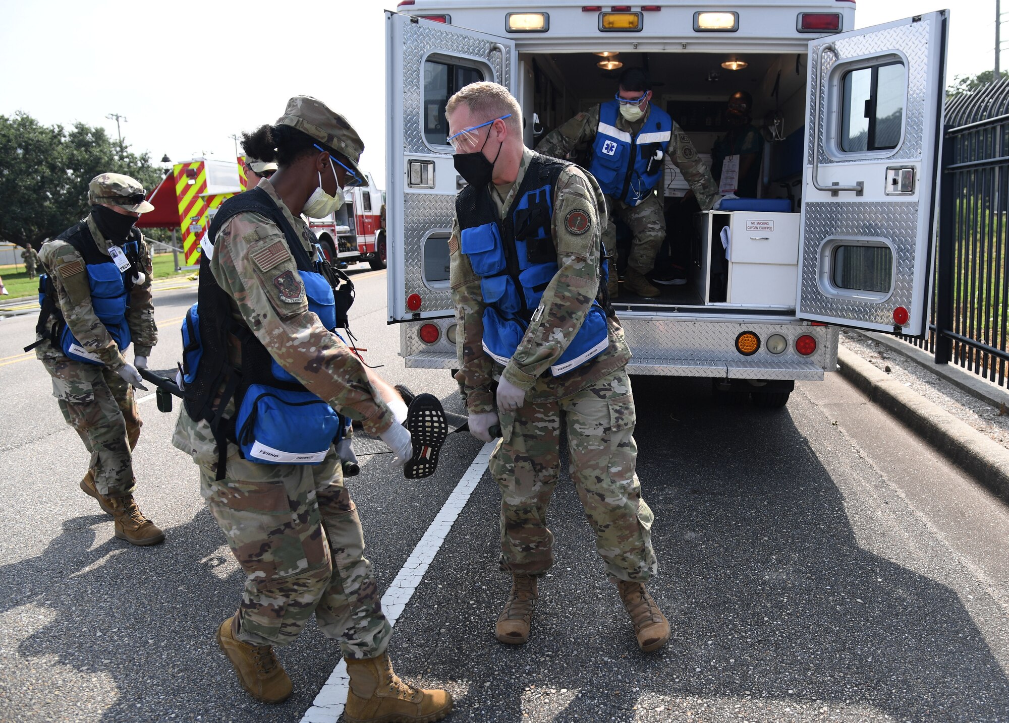 Members of the 81st Medical Group prepare to load a "victim" in the back of an ambulance during a Chemical, Biological, Radiological, Nuclear exercise at Keesler Air Force Base, Mississippi, Aug. 6, 2021. The Ready Eagle exercise tested the base's ability to respond to and recover from a mass casualty event. (U.S. Air Force photo by Kemberly Groue)