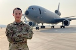 Female service member poses in front of aircraft