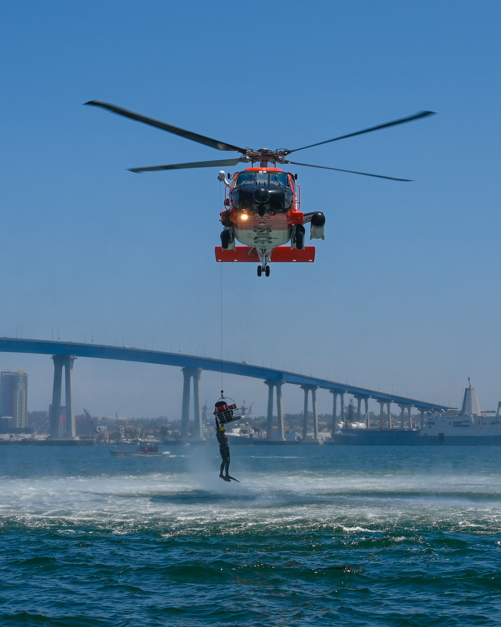 A U.S. Coast Guard MH-60J helicopter piloted by U.S. Coast Guard Lt. j.g. Tara Strauss hoists an Airmen out of the ocean while rescue swimmer Chief Petty Officer Tyler Holt prepares to drop back into the water at Naval Amphibious Air Base Coronado in San Diego, July 9. Pilots must complete water survival training every three years to maintain combat readiness.  (U.S. Air National Guard photo by Staff Sgt. Aubrey Pomares)