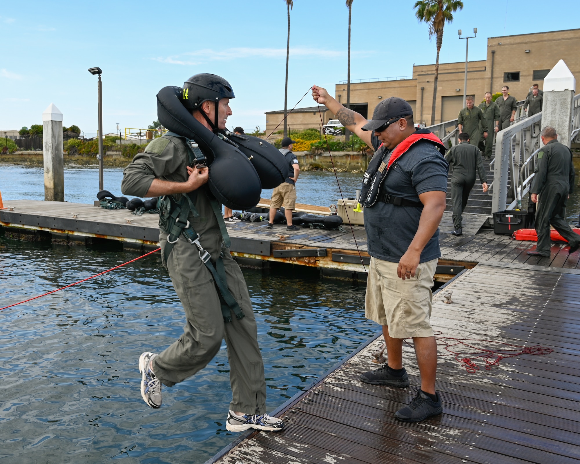 U.S. Air Force Brig. Gen. Jeffrey L. Butler, 162d Wing Commander, steps off the dock for the parachute drag portion of water survival training at Naval Amphibious Air Base Coronado in San Diego, July 10. Pilots must complete water survival training every three years to maintain combat readiness.  U.S. Air National Guard photo by Staff Sgt. Aubrey Pomares)