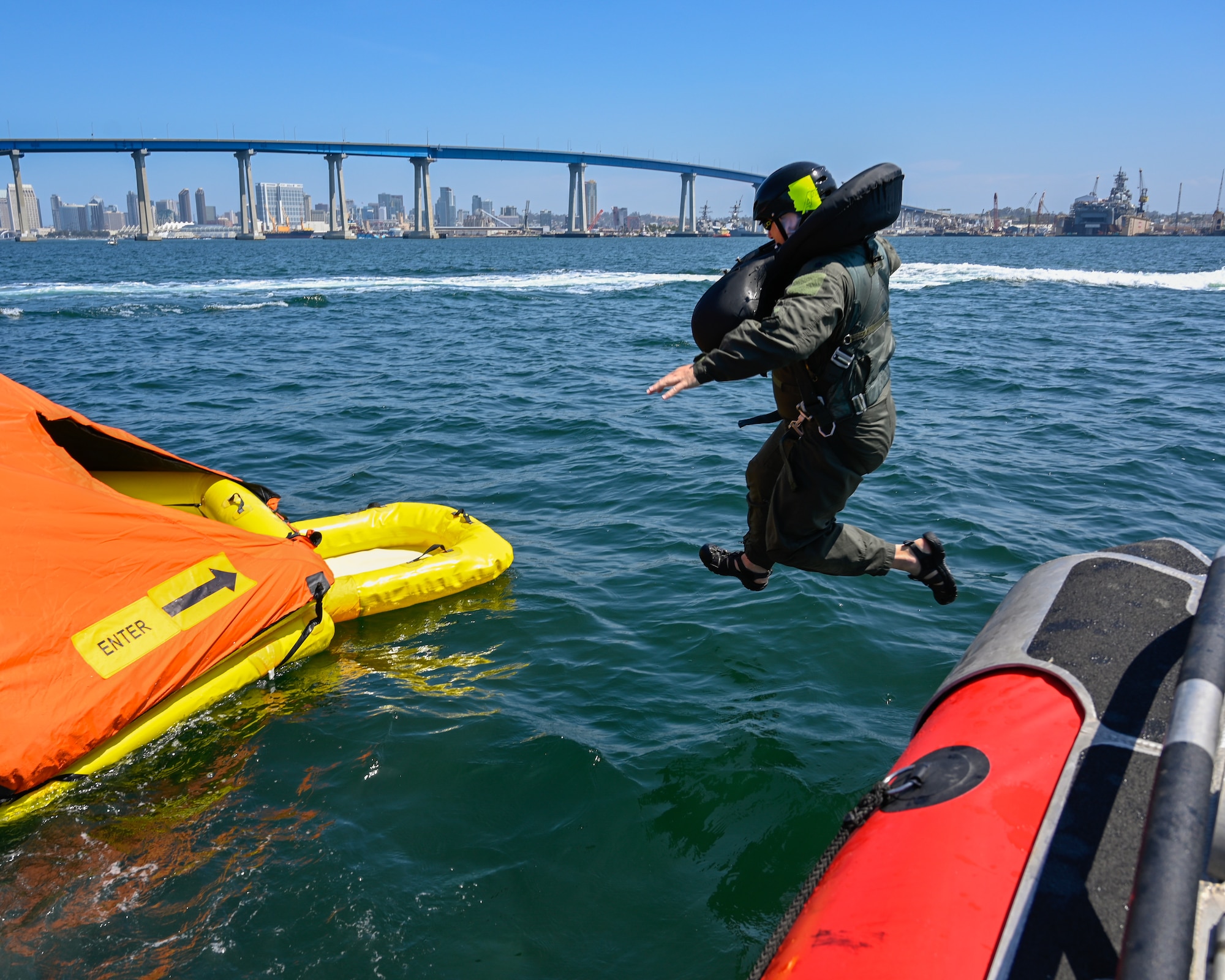 U.S. Air Force Tech Sgt. Alexandria Panduro, aircrew flight equipment technician at the 144th Fighter Wing, jumps towards the life raft to prepare for the helicopter extraction at Naval Amphibious Air Base Coronado, San Diego, July 10. Pilots must complete water survival training every three years to maintain combat readiness. (U.S. Air National Guard photo by Staff Sgt. Aubrey Pomares)