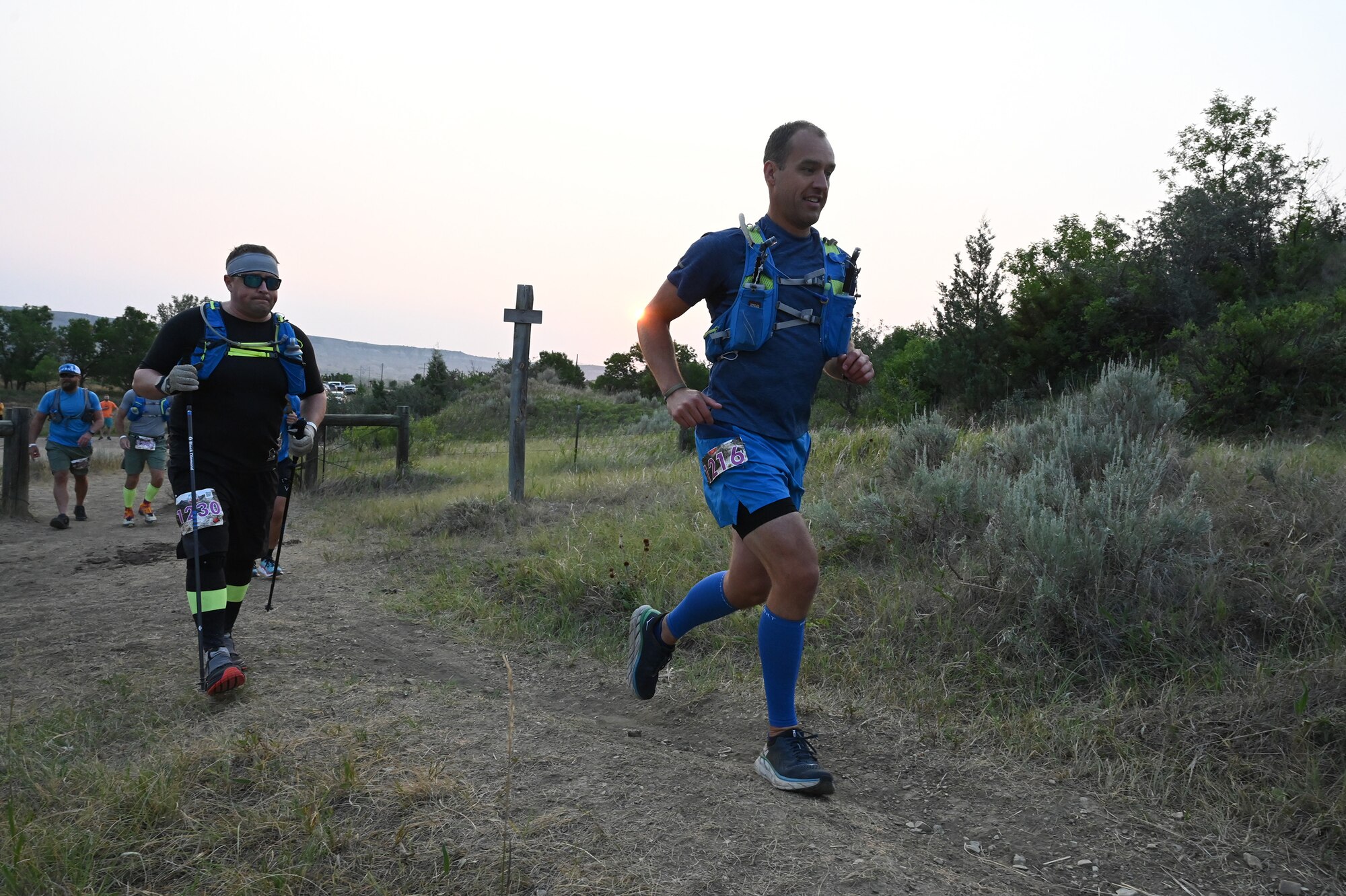 Ultramarathon runners begin running on a dirt path at the Maah Daah Hey Trail race in the early morning hours of July, 31, 2021.