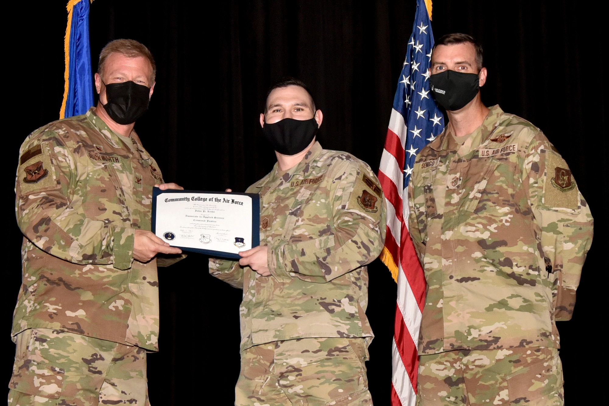 (center) Master Sgt. John Kuhn, 301st Fighter Wing Staff Agency, receives their Community College of the Air Force degree from (left) Col. Allen Duckworth, 301 FW commander, and (right) Chief Master Sgt. Michael Senigo, 301 FW command chief, during a graduation ceremony at U.S. Naval Air Station Joint Reserve Base Fort Worth, Texas, August 7, 2021. The college annually awards over 22,000 associate in applied science degrees from 71 degree programs. (U.S. Air Force photo by Staff Sgt. Randall Moose)