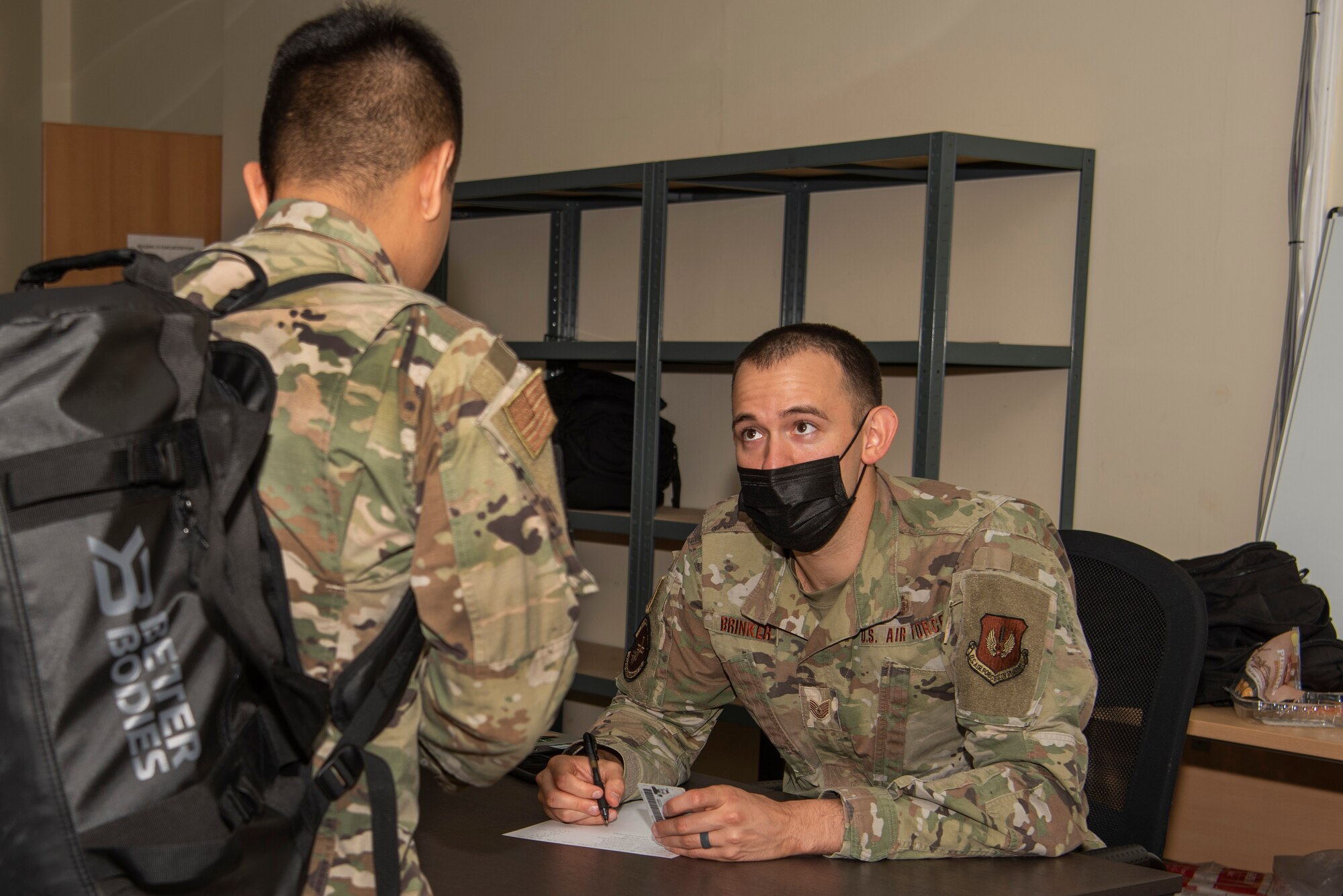 U.S. Air Force Tech. Sgt. Austin Brinker, 480th Expeditionary Fighter Squadron Public Health non-commissioned officer in charge, helps to inprocess U.S. service members arriving at  Łask Air Base, Poland, July 27, 2021. Airmen assigned to the 52nd Fighter Wing, Spangdahlem Air Base, Germany are in Poland to participate in Aviation Detachment Rotation 21.3 to increase interoperability with allied partners. (U.S. Air Force photo by Tech. Sgt. Anthony Plyler)