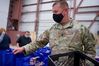 JOINT BASE ELMENDORF-RICHARDSON, Alaska -- Command Sgt. Maj. James Nyquist, state command sergeant major for the Alaska Army National Guard, arranges Alaska USO care packages before a Commissary sale Aug. 7, 2021, at the Alaska Army National Guard Aviation Facility, Bethel, Alaska. An Alaska Air National Guard C-17 Globemaster III moved tons of groceries and supplies from Joint Base Elmendorf-Richardson to Bethel to offer the goods to eligible residents at discount prices. (U.S. Air National Guard photo by David Bedard/Released)