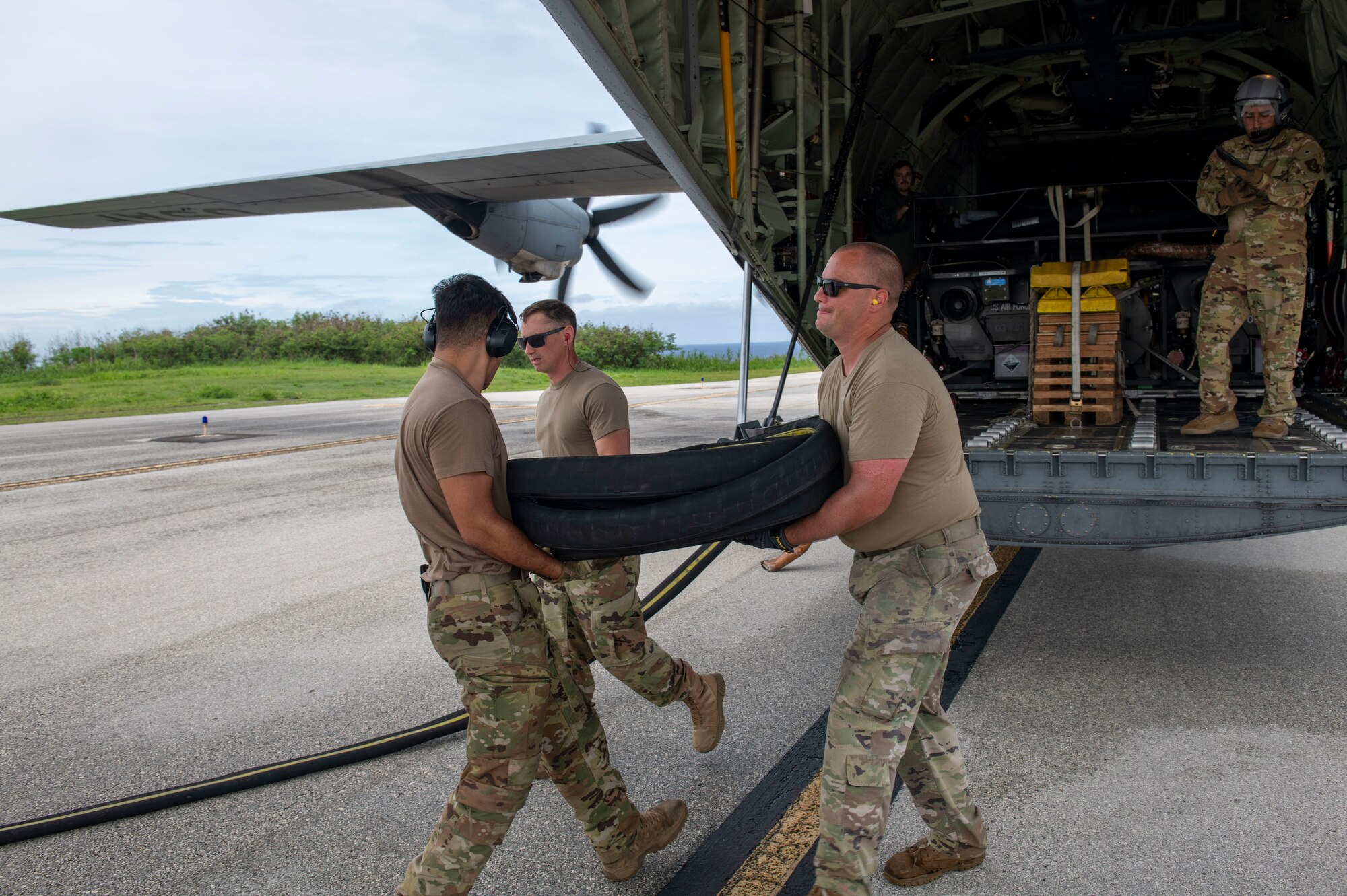 U.S. Air Force Airmen unload a fuel hose in preparation for an off-load of fuel from a C-130J Super Hercules July 25, 2021, at Tinian International Airport, Tinian, during Pacific Iron 2021.