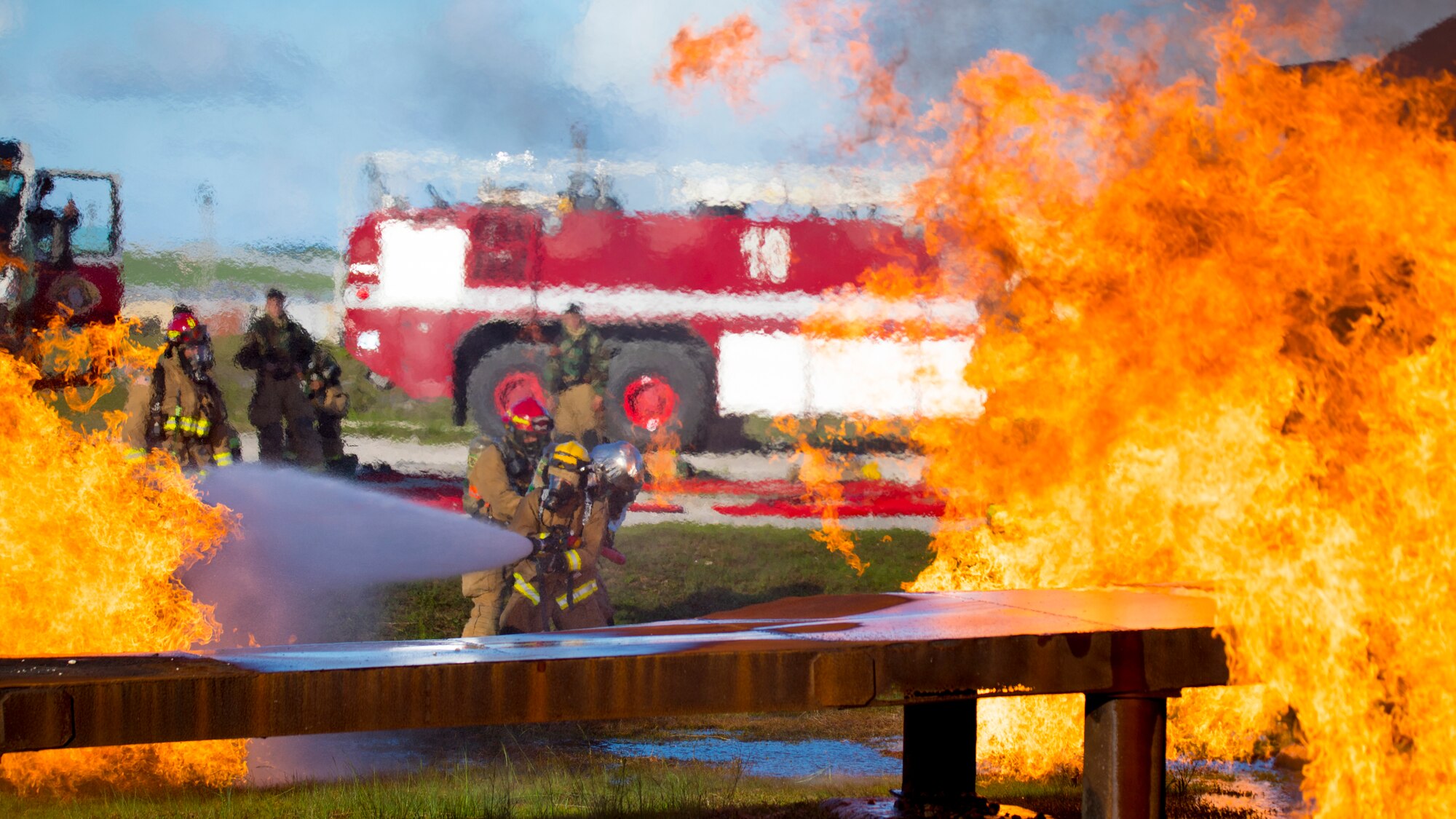 U.S. Marines with Marine Wing Support Squadron 171 and Airmen with the Andersen Air Force Base Fire and Emergency Services, 36th Civil Engineer Squadron extinguish a fire during a controlled burn exercise at Andersen Air Force Base, Guam, July 28, 2021. Marines, Airmen, and Guam International Airport Fire Department crash fire rescue take part in annual training exercises in order to remain proficient in firefighting and rescue procedures to ensure safe airfield operations. (U.S. Marine Corps photo by Lance Cpl. Tyler Harmon)