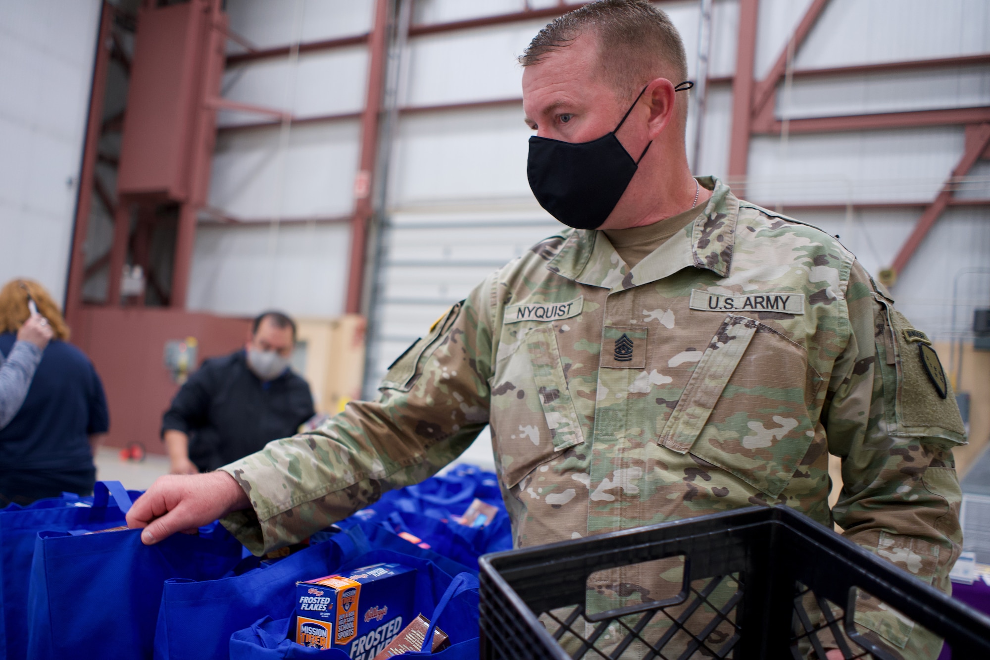 JOINT BASE ELMENDORF-RICHARDSON, Alaska -- Command Sgt. Maj. James Nyquist, state command sergeant major for the Alaska Army National Guard, arranges Alaska USO care packages before a Commissary sale Aug. 7, 2021, at the Alaska Army National Guard Aviation Facility, Bethel, Alaska. An Alaska Air National Guard C-17 Globemaster III moved tons of groceries and supplies from Joint Base Elmendorf-Richardson to Bethel to offer the goods to eligible residents at discount prices. (U.S. Air National Guard photo by David Bedard/Released)