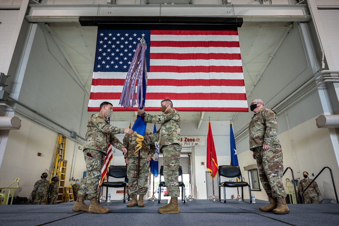Col. Bruce Bancroft (center) accepts the 123rd Airlift Wing guidon from Brig. Gen. Jeffrey Wilkinson (left), Kentucky’s assistant adjutant general for Air, during a ceremony at the Kentucky Air National Guard Base in Louisville, Ky., Aug. 7, 2021, formally recognizing Bancroft’s assumption of command of the wing from Col. David Mounkes (right). Mounkes, who had served as wing commander since 2016, has been named director of policy for air operations, plans and programs at Joint Forces Headquarters—Kentucky. (U.S. Air National Guard photo by Dale Greer)