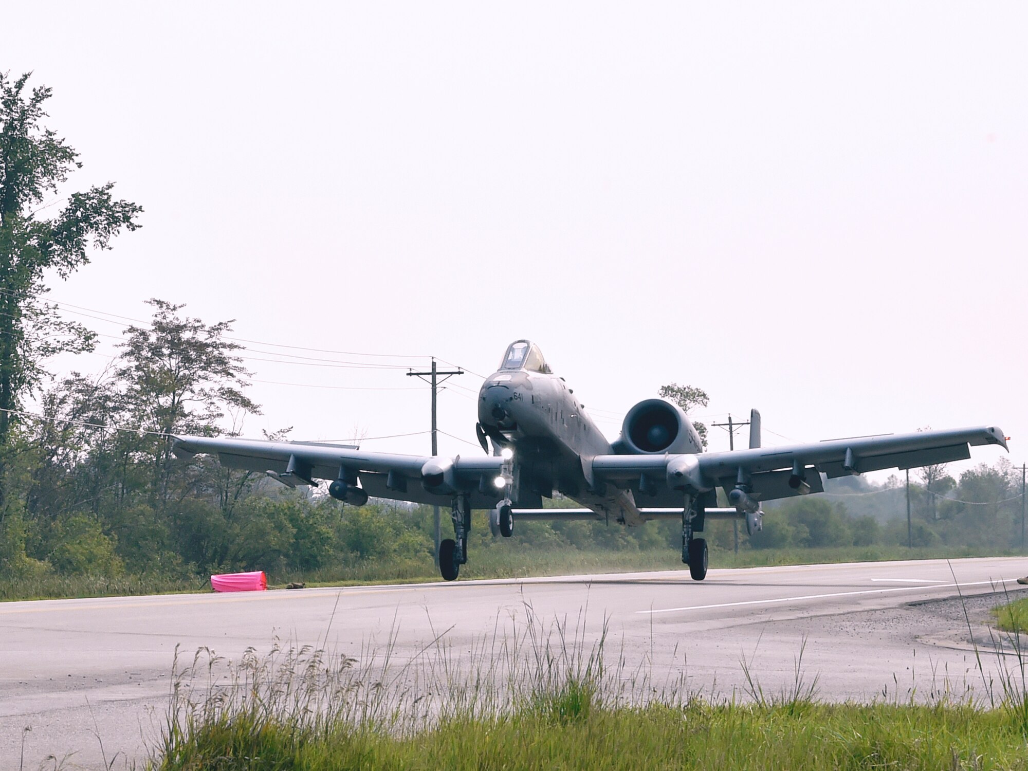 An A-10 Thunderbolt II pilot, 127th Wing, Selfridge Air National Guard Base, touches down on a pubic highway here, August 5, 2021. The training event marked the first time in U.S. history that a modern military aircraft landed on a U.S. public highway designed only for automobiles.