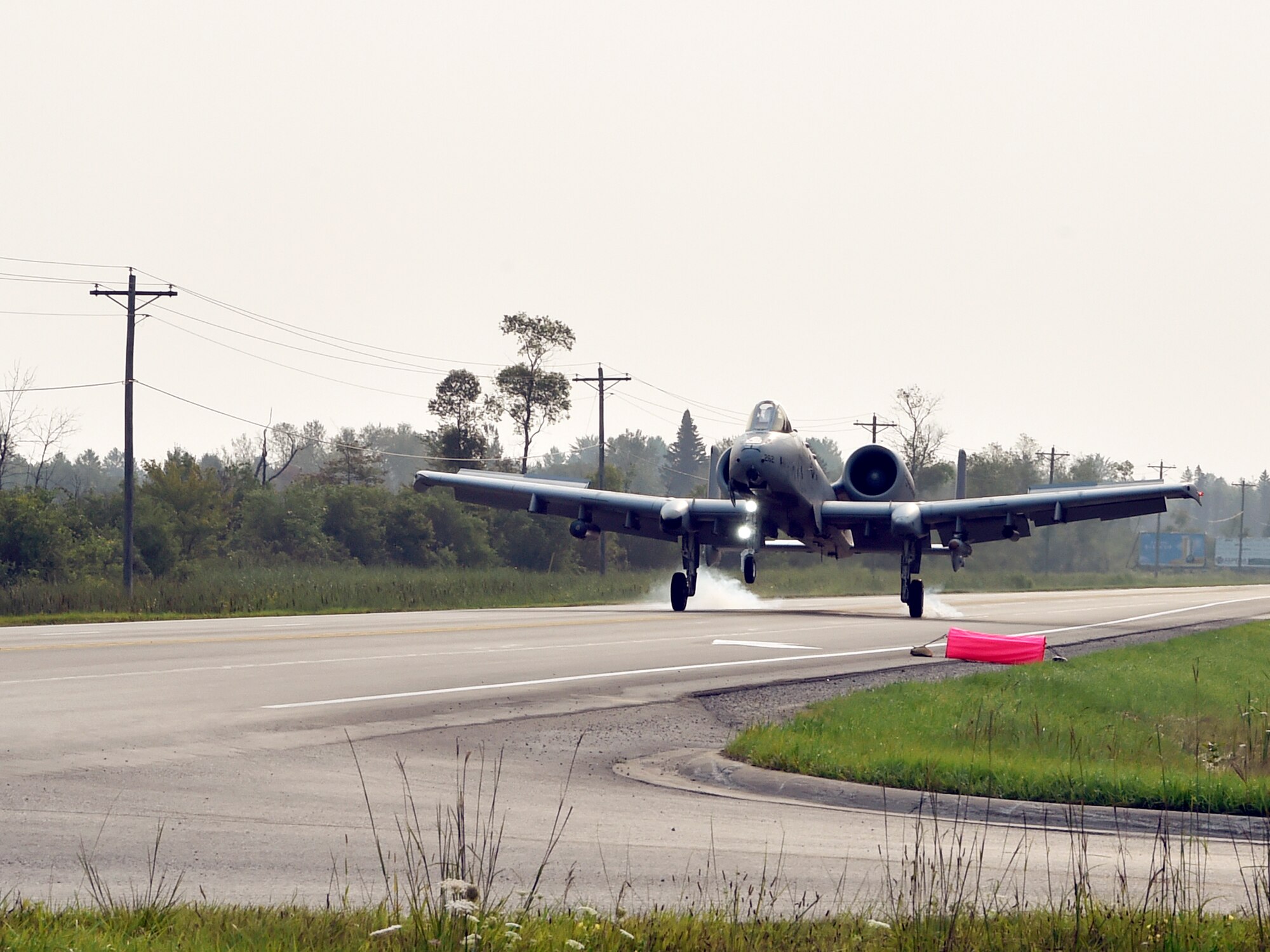 An A-10 Thunderbolt II pilot, 127th Wing, Selfridge Air National Guard Base, touches down on a pubic highway here, August 5, 2021. The training event marked the first time in U.S. history that a modern military aircraft landed on a U.S. public highway designed only for automobiles.