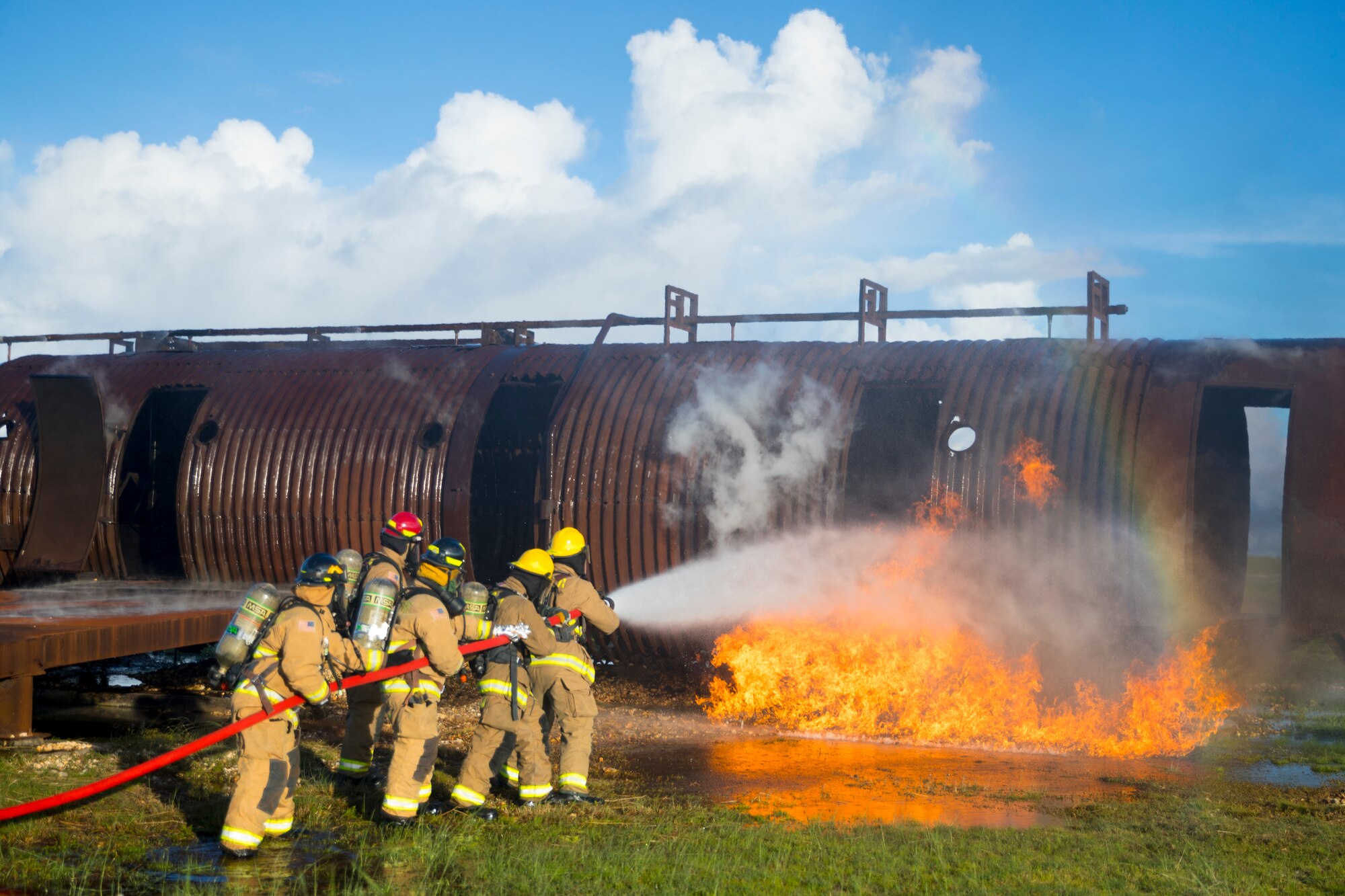 U.S. Marines with Marine Wing Support Squadron 171 and Airmen with the Andersen Air Force Base Fire and Emergency Services, 36th Civil Engineer Squadron extinguish a fire during a controlled burn exercise at Andersen Air Force Base, Guam, July 28, 2021. Marines, Airmen, and Guam International Airport Fire Department crash fire rescue take part in annual training exercises in order to remain proficient in firefighting and rescue procedures to ensure safe airfield operations. (U.S. Marine Corps photo by Lance Cpl. Tyler Harmon)