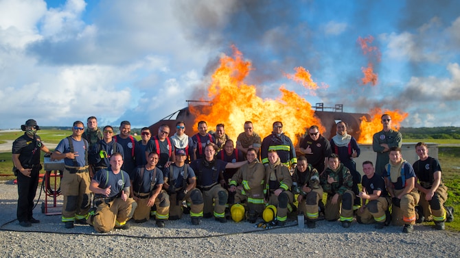 U.S. Marines with Marine Wing Support Squadron 171 and Airmen with the Andersen Air Force Base Fire and Emergency Services, 36th Civil Engineer Squadron and Guam International Airport Fire Department crash fire rescue personnel pose for a photo during a controlled burn exercise at Andersen Air Force Base, Guam, July 28, 2021. Marines, Airmen, and Guam International Airport Fire Department crash fire rescue take part in annual training exercises in order to remain proficient in firefighting and rescue procedures to ensure safe airfield operations. (U.S. Marine Corps photo by Lance Cpl. Tyler Harmon)