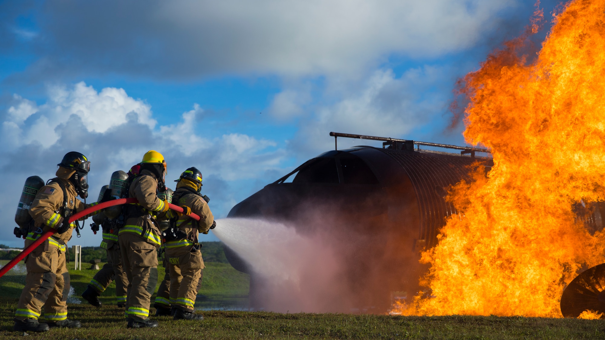 U.S. Marines with Marine Wing Support Squadron 171 and Airmen with the Andersen Air Force Base Fire and Emergency Services, 36th Civil Engineer Squadron extinguish a fire during a controlled burn exercise at Andersen Air Force Base, Guam, July 28, 2021. Marines, Airmen, and Guam International Airport Fire Department crash fire rescue take part in annual training exercises in order to remain proficient in firefighting and rescue procedures to ensure safe airfield operations. (U.S. Marine Corps photo by Lance Cpl. Tyler Harmon)