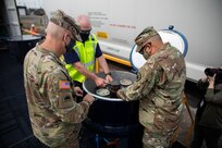 Mike Austin, director of hazardous materials for CSX transportation, demonstrates a simulated release valve onboard a CSX Responder Incident Training Train with Joint Task Force Civil Support Commanding General Maj. Gen. Jeff Van, right, and Brig. Gen. William Prendergast, commander of Task Force 51, during a distinguished visitors day as part of exercise Vibrant Response 21.2.