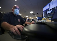 JOINT BASE LANGLEY-EUSTIS, Va. (Aug. 8, 2021) Kelly Comardelle, a Joint Task Force Civil Support (JTF-CS) watch officer, monitors the common operating picture to ensure it’s up to date and disseminates modifications to base orders to subordinate units during exercise Vibrant Response 21.2.