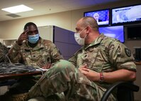 JOINT BASE LANGLEY-EUSTIS, Va. (Aug. 8, 2021) Army Lt. Col. Anterrio Gainwell, a Joint Task Force Civil Support (JTF-CS) Chemical, Biological, Radiological, Nuclear, Explosive cell augmentee assigned to the 20th CBRNE Command, discusses risk mitigation and mission analysis with JTF-CS CBRN Cell Chief Lt. Col. Patrick Bradley during exercise Vibrant Response 21.2.