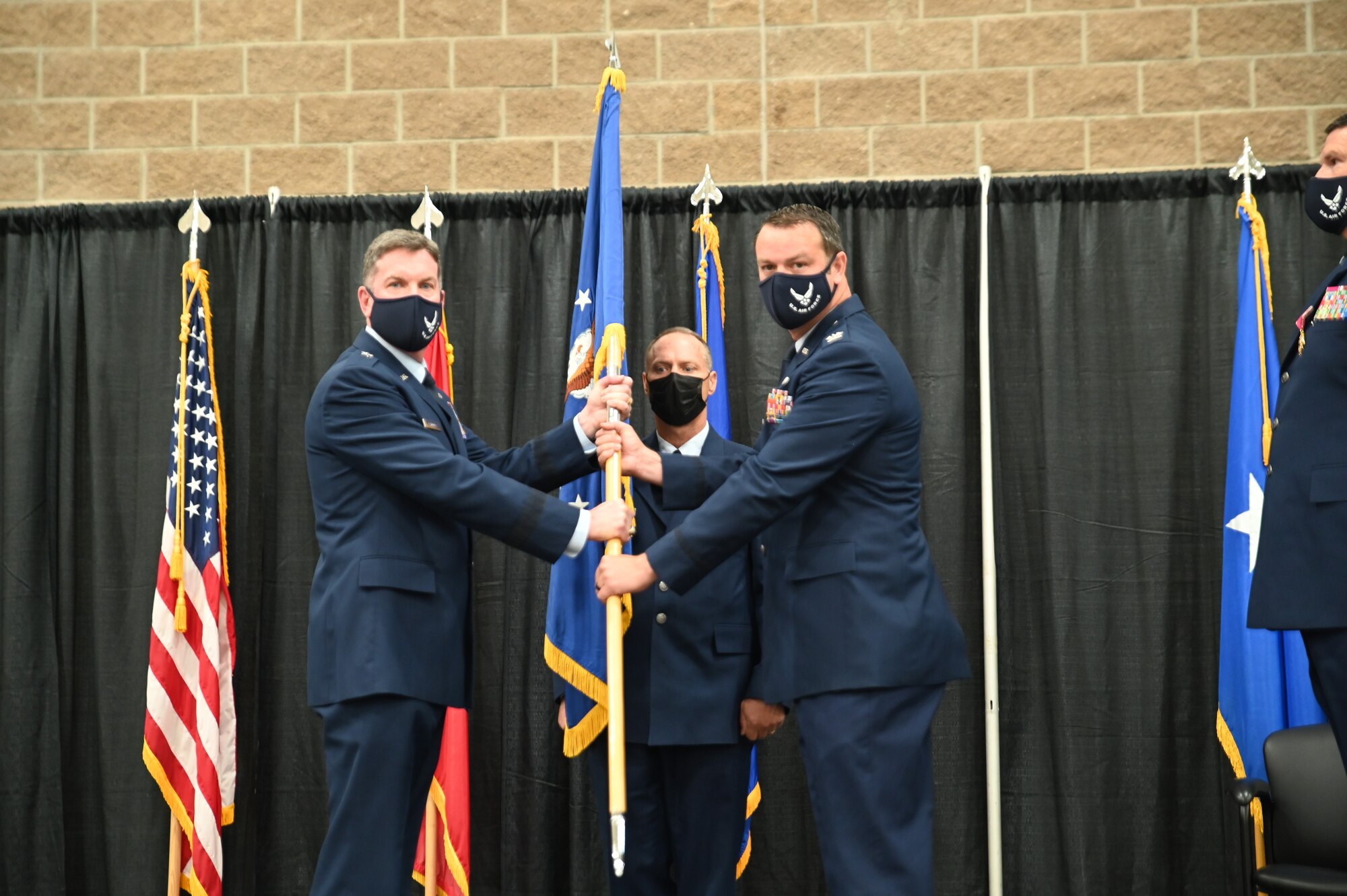 Big. Gen. Thomas D. Crimmins, Arkansas National Guard air component commander, passes the 188th Wing guidon to incoming commander Col. Jeremiah Gentry during a Change of command ceremony, Aug. 7, 2021.