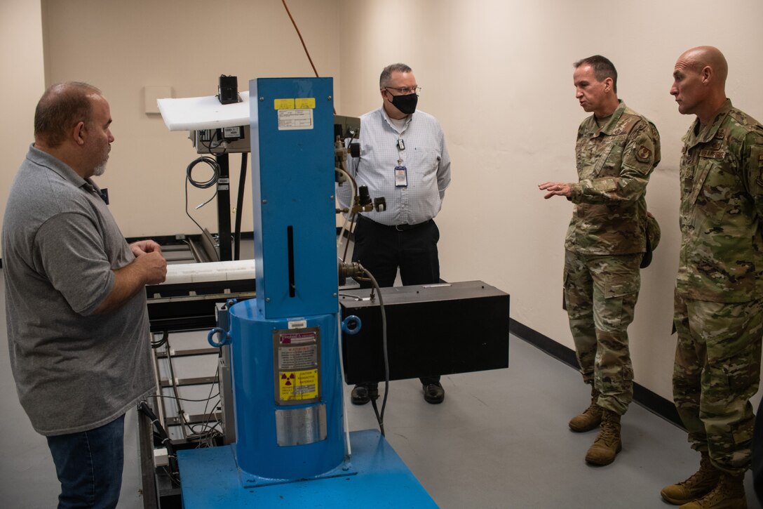 Lt. Gen. Shaun Q. Morris, Air Force Life Cycle Management Center commander, speaks with Norman Green, Air Force Metrology and Calibration technician, about the capabilities and functionality of their precision measurement equipment at the Air Force Primary Standards Laboratory, Heath, Ohio, during a site visit July 15, 2021.(U.S. Air Force photo by Tech. Sgt. Matthew B. Fredericks)