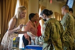 Sonya Struble, left, 56th Force Support Squadron Airman &amp; Family Readiness Center Exceptional Family Member Program-Family Support coordinator, shares an EFMP pamphlet with Senior Airman Niki Hargrove, 310th Fighter Squadron aviation resource management apprentice, during a wing newcomer’s orientation July 20, 2021, at Luke Air Force Base, Arizona. EFMP-FS coordinators help Airmen and their families identify their immediate and long-term needs, strengths and goals to ensure they feel supported when in need of specialized assistance. The EFMP helps support Airmen and their families by providing tailored services to aid in enhancing their quality of life and level of resiliency. (U.S. Air Force photo by Staff Sgt. Collette Brooks)