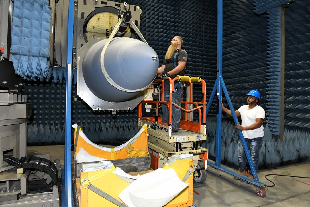 men hoisting aircraft nose cone