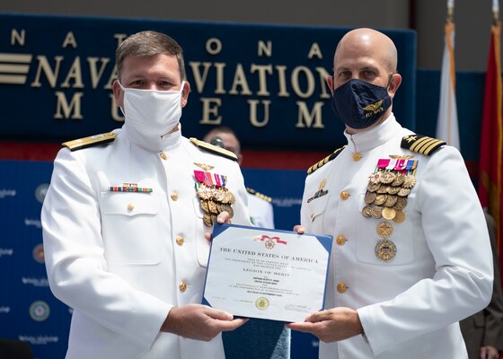 PENSACOLA, Fla. (Aug. 6, 2021) Chief of Naval Air Training Rear Adm. Robert Westendorff, left, presents Commodore, Training Air Wing (TW) 6 Capt. Scott Janik the Legion of Merit to recognize his excellent work during his time at the Wing. Janik relinquished command to Capt. Kenneth Russell during a ceremony at the National Naval Aviation Museum at Naval Air Station Pensacola, Aug. 6. TW-6 conducts all undergraduate naval flight officer training for the U.S. Navy and Marine Corps. (U.S. Navy photo by Lt. Michelle Tucker)