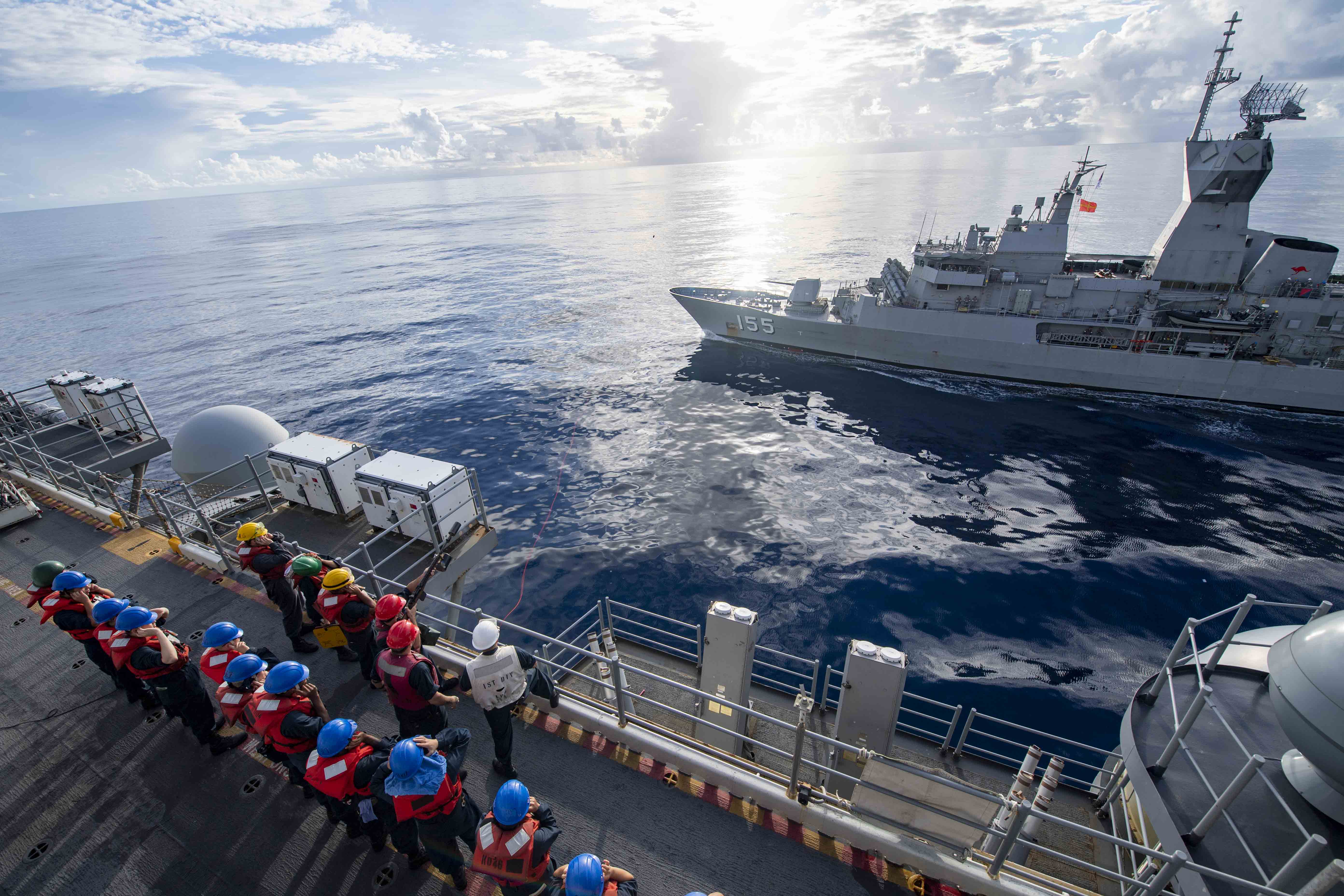 PACIFIC OCEAN (Aug. 6, 2021) Sailors aboard the forward-deployed amphibious assault ship USS America (LHA 6) prepare for a fueling-at-sea with the Royal Australian Navy frigate HMAS Ballarat (FFH 155).