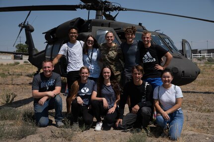 Freedom Academy delegates pose fo a photo in front of a helicopter