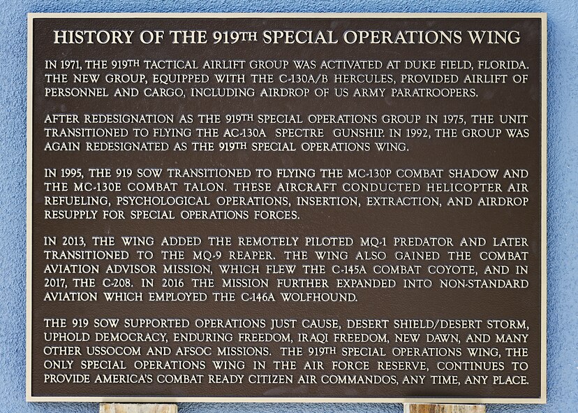 Metal plaque sits on wood planks leaned against concrete wall