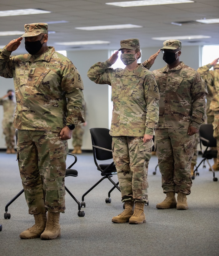 Command Sgt. Maj. Ciearro M. Faulk, Brig. Gen. Pamela L. McGaha, and Command Sgt. Maj. Ricardo M. Saunders render a hand salute during the playing of the National Anthem as part of the 143d Sustainment Command (Expeditionary)'s Change of Responsibility ceremony at its headquarters in Orlando, Fla.