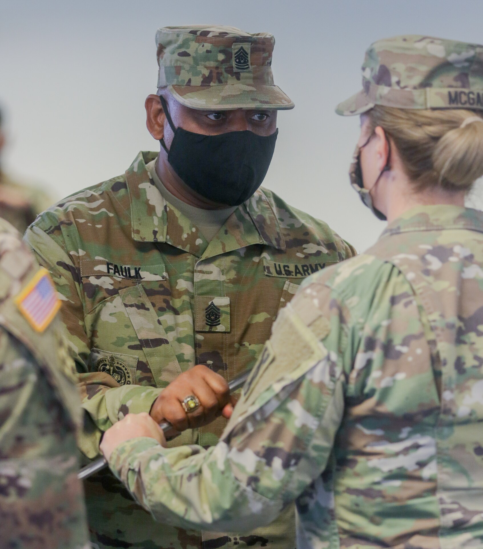 Command Sgt. Maj. Ciearro M. Faulk, outgoing senior enlisted advisor for the 143d Sustainment Command (Expeditionary), passes the NCO sword to Brig. Gen. Pamela L. McGaha, commanding general of the 143d ESC, during the command's Change of Responsibility ceremony held at its headquarters in Orlando, Fla.