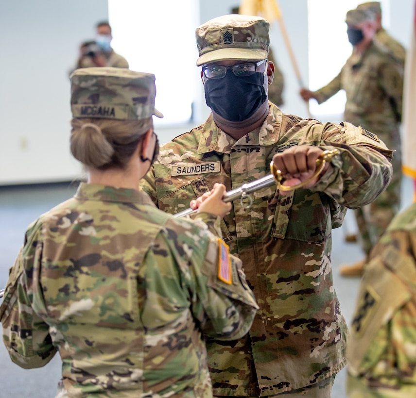 Brig. Gen. Pamela L. McGaha, commanding general of the 143d Sustainment Command (Expeditionary), passes the NCO sword to Command Sgt. Maj. Ricardo M. Faulk, the command's new senior enlisted advisor, during the command's Change of Responsibility ceremony held at its headquarters in Orlando, Fla.
