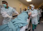 Members of the 555th Forward Surgical Team rush a simulated trauma patient to surgery during training